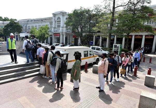 NEW DELHI, INDIA - APRIL 12: Commuters wait in a long queue outside Rajiv Chowk Metro Station after DMRC allowed travelers to enter in small groups as a preventive measure against the Covid-19 coronavirus, at Connaught Place, on April 12, 2021 in New Delhi, India. (Photo by Sonu Mehta Hindustan Times) Daily Life Amid Rise In Coronavirus Cases In India