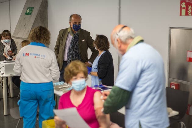 Spain: Vaccination at the WiZink Center A person being vaccinated with the first dose of Astra Zeneca at the WiZink Center in Madrid while behind the Vice Minister of Health of the Community of Madrid talks with the workers. Madrid Madrid Spain Copyright: FerxCapdeponxArroyo