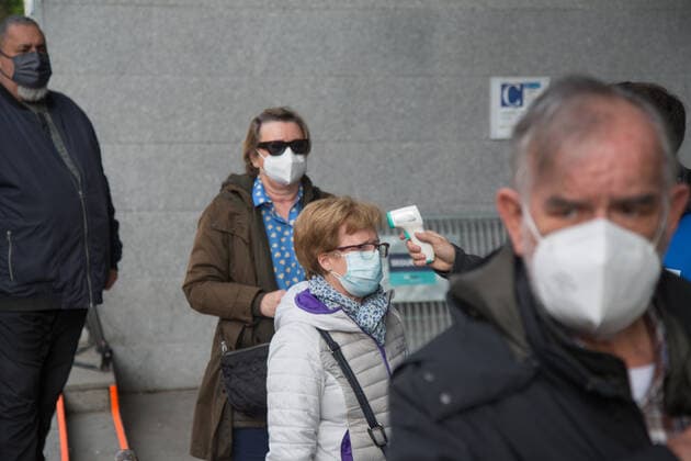 Spain: Vaccination at the WiZink Center A person takes the temperature of the people scheduled for vaccination before entering the WiZink Center in Madrid. Madrid Madrid Spain Copyright: FerxCapdeponxArroyo
