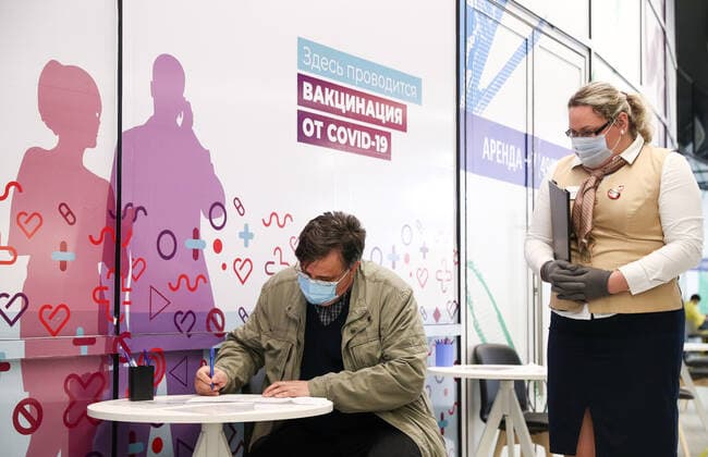 MOSCOW, RUSSIA â€“ APRIL 14, 2021: A man fills out an informed consent form to receive the Gam-COVID-Vac vaccine (under the brand name of Sputnik V) at a mobile COVID-19 vaccination site at the Arena Plaza shopping mall; the vaccine is provided free of charge and without prior sign-up. Mikhail Tereshchenko TASS  TS0FCB1C