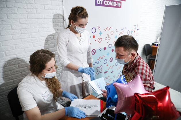 MOSCOW, RUSSIA â€“ APRIL 14, 2021: A man is given a certificate after receiving the Gam-COVID-Vac vaccine (under the brand name of Sputnik V) at a mobile COVID-19 vaccination site at the Arena Plaza shopping mall; the vaccine is provided free of charge and without prior sign-up. Mikhail Tereshchenko TASS  TS0FCB1D