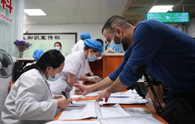 Coronavirus in China, Impfstart für Ausländer in Peking (210415) -- GUANGZHOU, April 15, 2021 -- A Tunisian national (1st, R) registers for COVID-19 vaccination at a hospital in Yuexiu District of Guangzhou, south China s Guangdong Province, April 15, 2021. Guangdong Province started administering COVID-19 vaccines to foreigners in the province on April 15 on a voluntary basis. Foreign nationals who are covered by the local health insurance program can be vaccinated for free, enjoying the same policy as insured Chinese citizens, and those not covered will be charged 100 yuan (about 15 U.S. dollars) per dose. ) CHINA-GUANGDONG-FOREIGNERS-COVID-19-VACCINATION (CN) DengxHua 