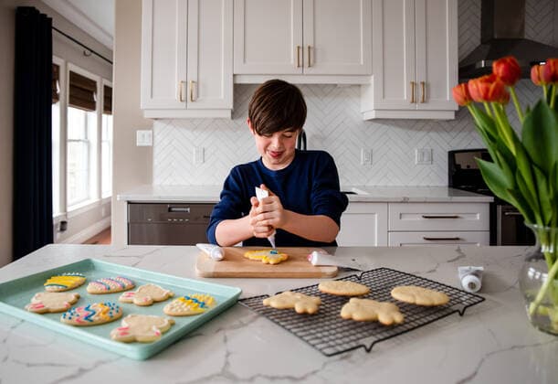Young boy decorating Easter cookies on counter of a modern kitchen. Kingston, ON, Canada CR_DOHO210416K-712609-01 ,model released, Symbolfoto