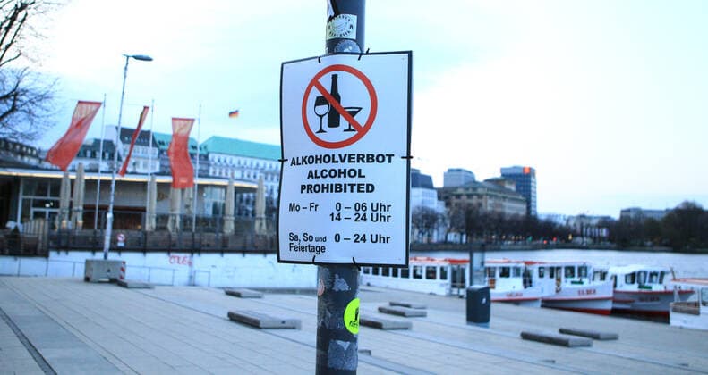 Menschenleerer Alsteranleger am Jungfernstieg in den Abendstunden während des Lockdowns. Ein Schild weist darauf hin, dass hier zu bestimmten Zeiten Alkoholverbot besteht. Innenstadt Hamburg