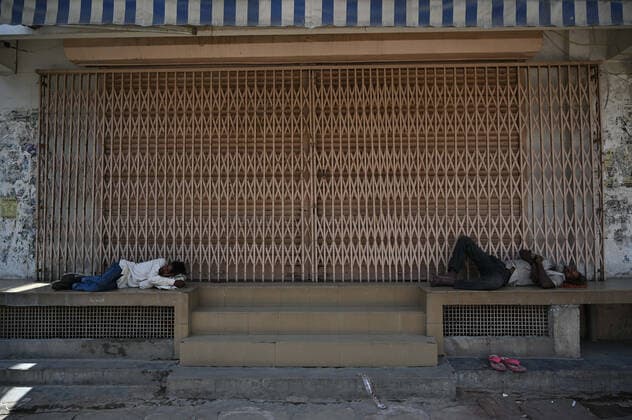 April 18, 2021, Allahabad, Uttar Pradesh, India: Prayagraj: Labours rest in front of Closed shop on first day of weekly lockdown during COVID-19 spread in Prayagraj on Sunday, April 18, 2021. Allahabad India - ZUMAv115 20210418_zap_v115_005 Copyright: xPrabhatxKumarxVermax