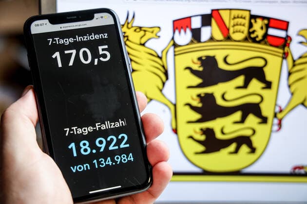 Coronavirus in Deutschland - Covid-19-Dashboard des Robert Koch-Institut DEU, Deutschland, Baden-Württemberg, 18.04.2021: Die 7-Tage-Inzidenz für das Bundesland (Fälle letzte 7 Tage 100.000 EW) wird auf einem iPhone angezeigt, im Hintergrund das Landeswappen