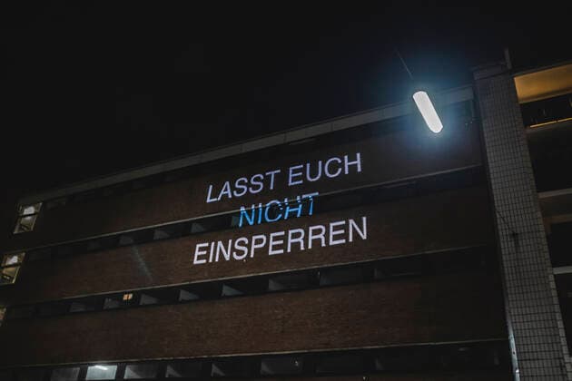 Ausgangssperre in Köln Köln, Innenstadt, 17.04.21-18.04.21: Bilddokumentation der Ausgangssperre von 21Uhr bis 5Uhr, ein Beamer wirft politische Aussagen auf ein gegenüberliegendes Gebäude, hier mit Lasst euch nicht einsperren .