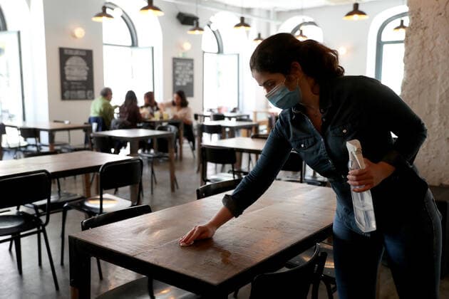 April 19, 2021, Lisbon, Portugal: A waiter cleans a table at a restaurant in Lisbon, Portugal on April 19, 2021. Portugal begins third phase of COVID-19 unlocking on Monday with the reopening of high schools, universities, cinemas, shopping malls and indoor areas of restaurants reopened in the vast majority of the mainland Portugal but stricter rules will stay in place in municipalities where transmission rates remain high. Lisbon Portugal - ZUMAf123 20210419_zap_f123_013 Copyright: xPedroxFiuzax