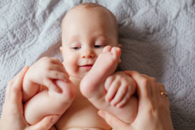 Good morning concept. Cute naked baby inspecting his body. Uzhhorod, Zakarpattia Oblast, Ukraine CR_OKSH210419C-716007-01 ,model released, Symbolfoto