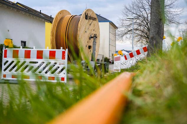 Rheinbach, Nordrhein-Westfalen, Deutschland - Internet Breitbandausbau, Baustelle Erdverlegung von Glasfasekabel, Kabeltrommel mit Glasfaserkabel, Neubau von Glasfasertrassen im Auftrag der Telekom, schnelles Internet, DSL Kabelanschluss fuer die Haushalte. Rheinbach Nordrhein-Westfalen Deutschland