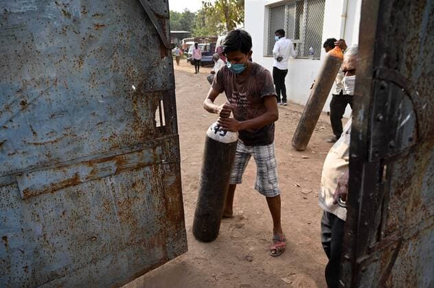 April 20, 2021, Allahabad, Uttar Pradesh, India: Prayagraj: A family member of COVID 19 patient carries a cylinder filled with medicated oxygen after refilling at a plant as Corona virus cases surge across the country, in Prayagraj on Tuesday, April 20, 2021. Allahabad India - ZUMAv115 20210420_zap_v115_001 Copyright: xPrabhatxKumarxVermax