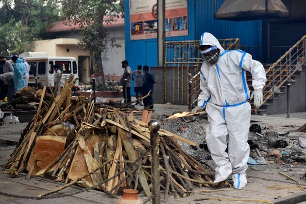 NEW DELHI, INDIA - APRIL 20: Relative of a Covid-19 victim performs the last rites, at Nigambodh Ghat crematorium on April 20, 2021 in New Delhi, India. India reports 1,761 COVID-19 deaths in the past 24 hours the highest daily toll since the pandemic erupted. (Photo by Sanjeev Verma Hindustan Times) Cremation Of Covid Victims