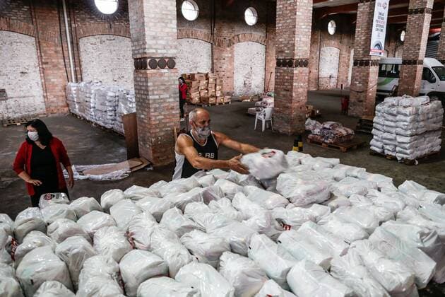 Volunteers carry food in the shed of Ação da Cidadania (Citizenship Action), an NGO founded by sociologist Herbert de Souza, in Rio de Janeiro, Brazil, 22 April 2021. Hundreds of people who live on the streets of Rio de Janeiro, or who have ended up there because of the pandemic, receive at least one plate of food a day in the city center, a figure much lower than a year ago for the crash in donations. In Rio de Janeiro, volunteers help alleviate the hunger caused by the covid-19 !ACHTUNG: NUR REDAKTIONELLE NUTZUNG!  Copyright: xAndréxCoelhox AME1803 20210422-637547213132431574