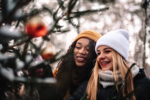 Happy girlfriends decorating Christmas tree outdoors CR_DMBE210422-676719-01 ,model released, Symbolfoto