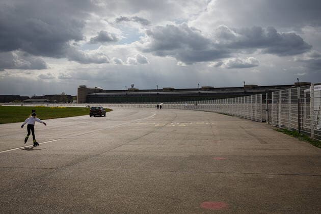 Skater auf dem Tempelhofer Feld Berlin: Roller-Skater auf den Gelände des Tempelhofer Feld mit Gewitterwolken im Hintergund.