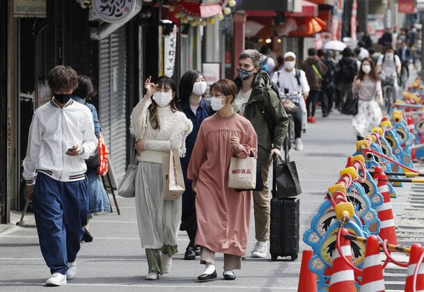 COVID-19 state of emergency declared for Tokyo, Osaka region People wearing face masks walk in Osaka on April 23, 2021. Prime Minister Yoshihide Suga declared a state of emergency the same day in Tokyo and the western Japan prefectures of Osaka, Kyoto and Hyogo amid a rapid resurgence of coronavirus infections. 