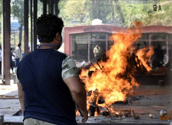 NEW DELHI, INDIA - APRIL 16: Relatives of a person who died of Covid-19 perform the last rites during the cremation at Nigambodh Ghat crematorium, on April 16, 2021 in New Delhi, India. (Photo by Sonu Mehta Hindustan Times) Covid Death Toll Continues To Rise In India