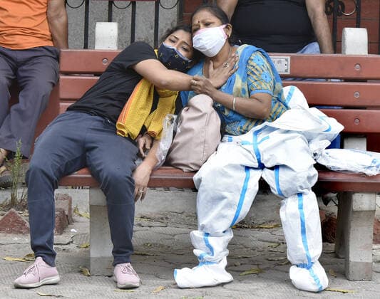 NEW DELHI, INDIA - APRIL 16: Relatives of a person who died of Covid-19 react during the cremation at Nigambodh Ghat crematorium, on April 16, 2021 in New Delhi, India. (Photo by Sonu Mehta Hindustan Times) Covid Death Toll Continues To Rise In India