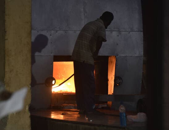 NEW DELHI, INDIA - APRIL 16: Relatives of a person who died of Covid-19 perform the last rites during the cremation at Nigambodh Ghat crematorium, on April 16, 2021 in New Delhi, India. (Photo by Sonu Mehta Hindustan Times) Covid Death Toll Continues To Rise In India