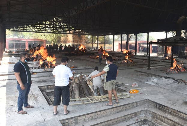 NEW DELHI, INDIA - APRIL 16: Relatives of a person who died of Covid-19 perform the last rites during the cremation at Nigambodh Ghat crematorium, on April 16, 2021 in New Delhi, India. (Photo by Sonu Mehta Hindustan Times) Covid Death Toll Continues To Rise In India