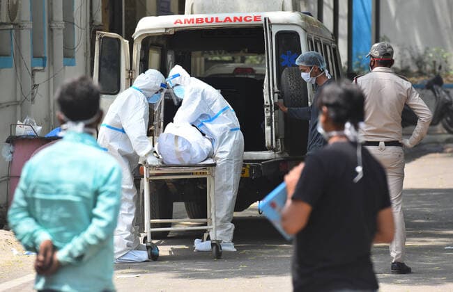 Coronavirus in Indien, Eindrücke aus Neu-Delhi NEW DELHI, INDIA APRIL 23: A medical team wheels out the body of a person who died of Covid-19 during a handover to family members outside the mortuary, at Lok Nayak Jai Prakash (LNJP) hospital, on April 23, 2021 in New Delhi, India. (Photo by Raj K Raj Hindustan Times ) Daily Life Amid Coronavirus Pandemic In India