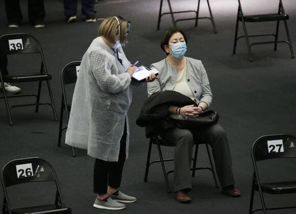Coronavirus in den USA, Impfzentrum im American Museum of Natural History in New York Healthcare workers attends to a woman in the observation area after being vaccinated under the famous 94-foot-long model of a blue whale when the American Museum of Natural History is transformed into a mass vaccination site at the AMNH in New York City on Friday, April 23, 2021.  NYP20210423114 JohnxAngelillo