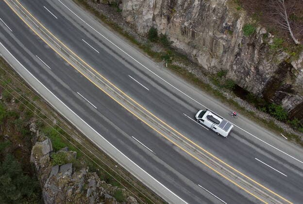 April 23, 2021, Lions Bay, BC, Canada: A motorist in a camper van outfitted with solar panels and a cyclist travel on the Sea-to-Sky highway between Horseshoe Bay and Lions Bay, B.C., on Friday, April 23, 2021. Non-essential travel is being restricted between three regional zones in British Columbia to try and curb the spread of COVID-19. Lions Bay Canada  - ZUMAc35_ 20210423_zaf_c35_076 Copyright: xDarrylxDyckx