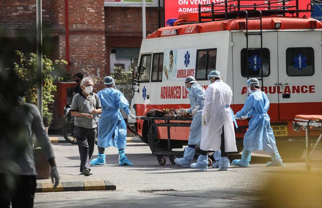 April 23, 2021, New Delhi, India: Health workers wearing protective suits help a Covid-19 suspected patient brought at Lok Nayak Jai Prakash (LNJP) Hospital in Old Delhi..India is running out of oxygen during the second wave of Covid-19 pandemic. India has recorded 332,730 new Covid-19 cases in a single day and 2,263 deaths in the last one day. New Delhi India - ZUMAs197 20210423_zaa_s197_319 Copyright: xNaveenxSharmax
