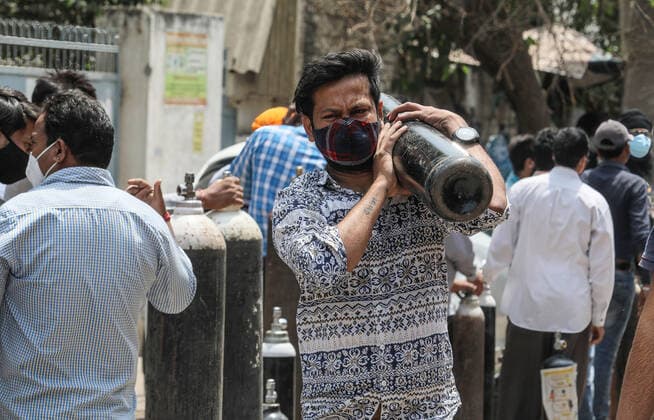 April 23, 2021, New Delhi, India: A family member of Covid-19 infected patient carries an empty cylinder to refill outside the oxygen filling center in New Delhi..India is running out of oxygen during the second wave of Covid-19 pandemic. India has recorded 332,730 new Covid-19 cases in a single day and 2,263 deaths in the last one day. New Delhi India - ZUMAs197 20210423_zaa_s197_329 Copyright: xNaveenxSharmax