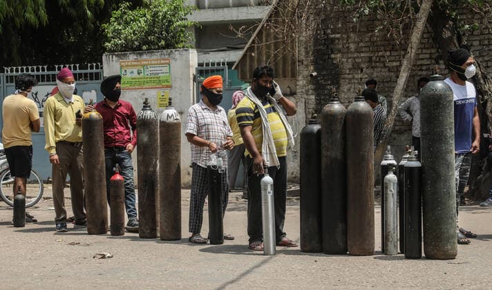 April 23, 2021, New Delhi, India: Family members of Covid-19 infected patients stand in a queue with empty oxygen cylinders outside the oxygen filling center in New Delhi..India is running out of oxygen during the second wave of Covid-19 pandemic. India has recorded 332,730 new Covid-19 cases in a single day and 2,263 deaths in the last one day. New Delhi India - ZUMAs197 20210423_zaa_s197_341 Copyright: xNaveenxSharmax