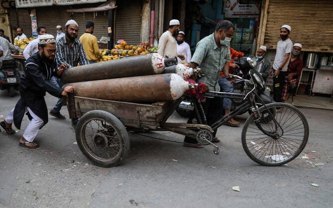 April 23, 2021, New Delhi, India: Family members of a Covid-19 infected patient push a hand cart with empty oxygen cylinders to refill at a oxygen filling center in Old Delhi..India is running out of oxygen during the second wave of Covid-19 pandemic. India has recorded 332,730 new Covid-19 cases in a single day and 2,263 deaths in the last one day. New Delhi India - ZUMAs197 20210423_zaa_s197_349 Copyright: xNaveenxSharmax