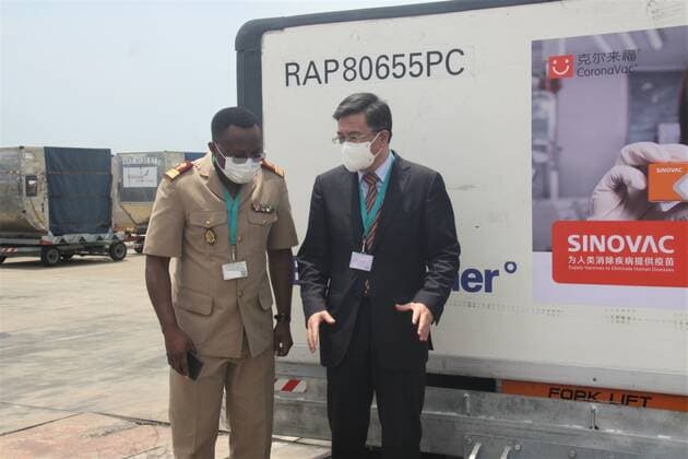 (210424) -- LOME, April 24, 2021 -- Chinese ambassador to Togo Chao Weidong (R) and Togolese national coordinator for COVID-19 response Djibril Mohaman talk in front of a batch of Sinovac vaccine donnated by China at the Gnassingbe Eyadema International Airport in Lome, Togo, April 23, 2021. The government of Togo received a batch of Sinovac vaccine donnated by China on Friday in support to its fight against COVID-19 as part of the cooperation between the two countries. (Photo by Xinhua) TOGO-LOME-COVID-19-SINOVAC-VACCINE Koffi 