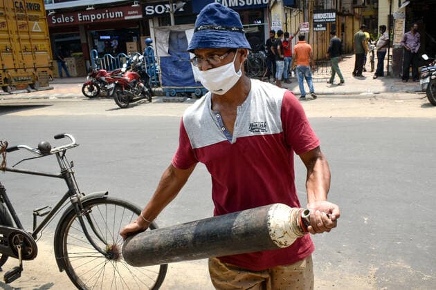 India: Oxygen crisis due to the increase of Corona virus cases in Kolkata A Family members of Covid-19 infected patients are carrying an oxygen cylinder during the oxygen crisis situation, amid the spread of Corona virus (Covid-19) in Kolkata. Kolkata West Bengal India Copyright: SudiptaxDas