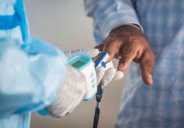 PUNE, INDIA - APRIl 23: A health worker (not in picture) in PPE kit checks oxygen level of a passenger at Pune railway station, on April 23, 2021 in Pune, India. (Photo by Pratham Gokhale Hindustan Times) Daily Life Amid Coronavirus Pandemic In India