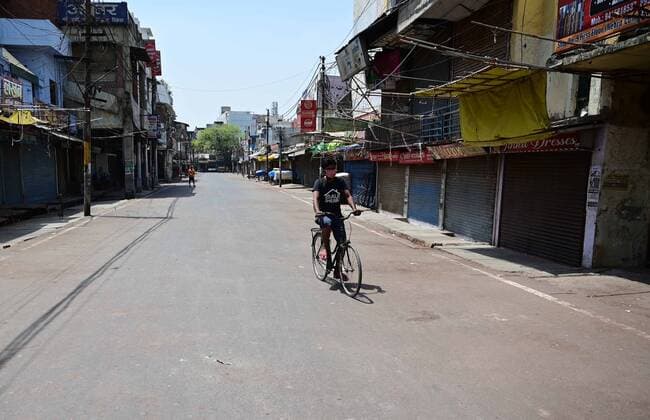 April 24, 2021, Prayagraj, Uttar Pradesh, India: Prayagraj: A cyclist paddle cycle past closed shop at Chauwk area during a weekend lockdown imposed by the government as a preventive measure against the Covid-19 coronavirus, in Prayagraj on Saturday, April 24, 2021. Prayagraj India - ZUMAv115 20210424_zap_v115_011 Copyright: xPrabhatxKumarxVermax