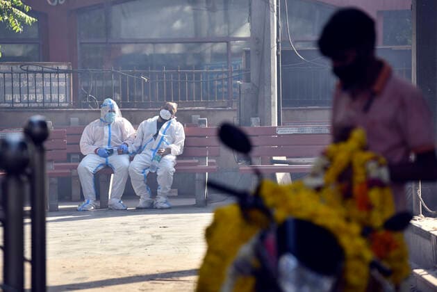 NEW DELHI, INDIA APRIL 24: Relatives of a person who died of Covid-19 waiting to cremate the body at Nigambodh Ghat crematorium, on April 24, 2021 in New Delhi, India. (Photo by Sanjeev Verma Hindustan Times ) Covid Death Toll Continues To Rise In India
