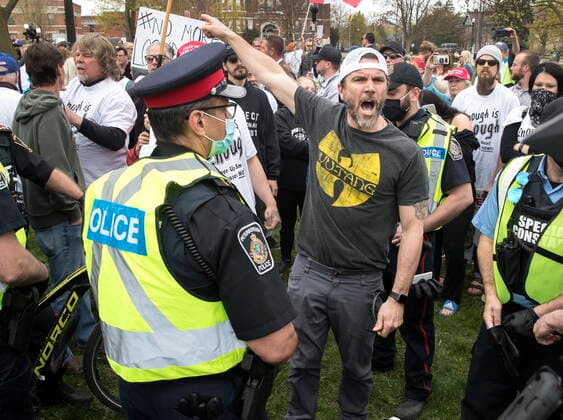 April 24, 2021, Peterborough, on, Canada: A demonstrator argues with police at a protest against government measures to curb the spread of COVID-19, in Peterborough, Ont., Saturday, April 24, 2021. Peterborough Canada  - ZUMAc35_ 20210424_zaf_c35_034 Copyright: xFredxThornhillx