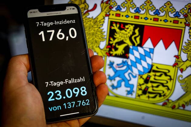 Coronavirus in Deutschland - Covid-19-Dashboard des Robert Koch-Institut DEU, Deutschland, Bayern, 25.04.2021: Die 7-Tage-Inzidenz für das Bundesland (Fälle letzte 7 Tage 100.000 EW) wird auf einem iPhone angezeigt, im Hintergrund das Landeswappen