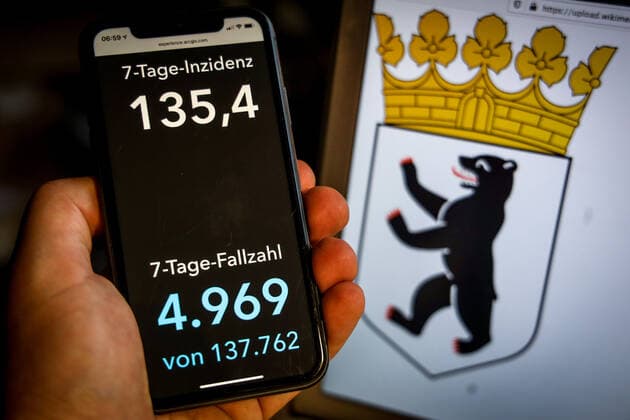 Coronavirus in Deutschland - Covid-19-Dashboard des Robert Koch-Institut DEU, Deutschland, Berlin, 25.04.2021: Die 7-Tage-Inzidenz für das Bundesland (Fälle letzte 7 Tage 100.000 EW) wird auf einem iPhone angezeigt, im Hintergrund das Landeswappen