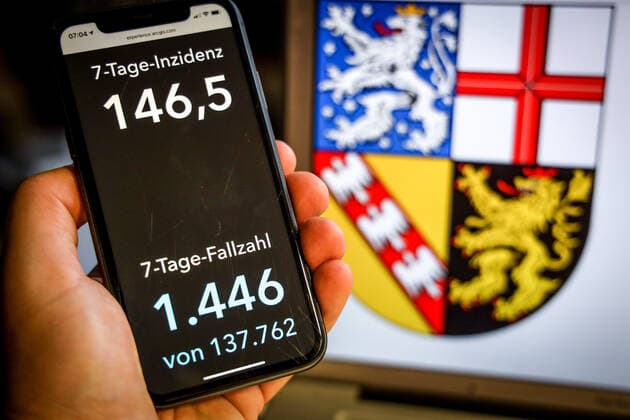 Coronavirus in Deutschland - Covid-19-Dashboard des Robert Koch-Institut DEU, Deutschland, Saarland, 25.04.2021: Die 7-Tage-Inzidenz für das Bundesland (Fälle letzte 7 Tage 100.000 EW) wird auf einem iPhone angezeigt, im Hintergrund das Landeswappen