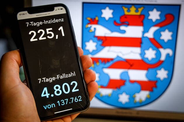 Coronavirus in Deutschland - Covid-19-Dashboard des Robert Koch-Institut DEU, Deutschland, Thüringen, 25.04.2021: Die 7-Tage-Inzidenz für das Bundesland (Fälle letzte 7 Tage 100.000 EW) wird auf einem iPhone angezeigt, im Hintergrund das Landeswappen