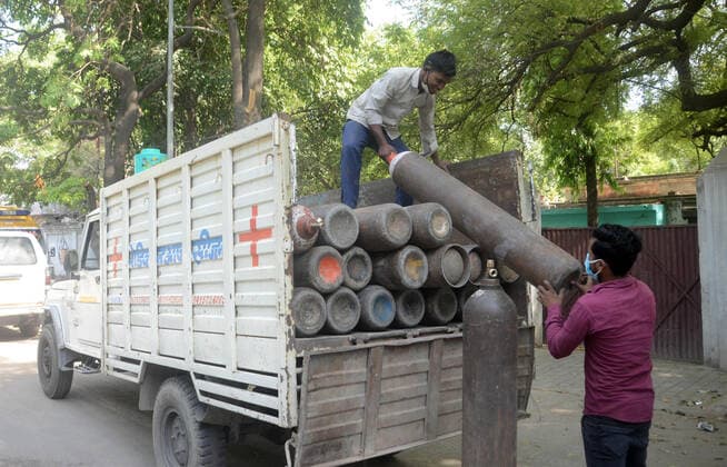 April 25, 2021, Prayagraj, Uttar Pradesh, India: Prayagraj: Hospital workers unload Medicated oxygen cylinder during government imposed weekend lockdown in wake of spread of CORONA virus in Prayagraj on Sunday, April 25, 2021. Prayagraj India - ZUMAv115 20210425_zap_v115_009 Copyright: xPrabhatxKumarxVermax