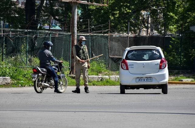 April 25, 2021, Kashmir, Jammu & Kashmir, India: A policeman stops a vehicle during the imposed curfew..Amid the second wave of the pandemic sweeping across the India, Authorities in Kashmir imposed a 34-hour curfew on Saturday. The curfew which was imposed at 8 pm on Saturday will remain effective till 6 am on Monday. Meanwhile, India s coronavirus cases and deaths hit a new record with 3.49 lakh fresh infections, taking the case load to 1.69 crore, 2,767 people died in the last 24 hours. Kashmir India - ZUMAs197 20210425_zaa_s197_012 Copyright: xSaqibxMajeedx