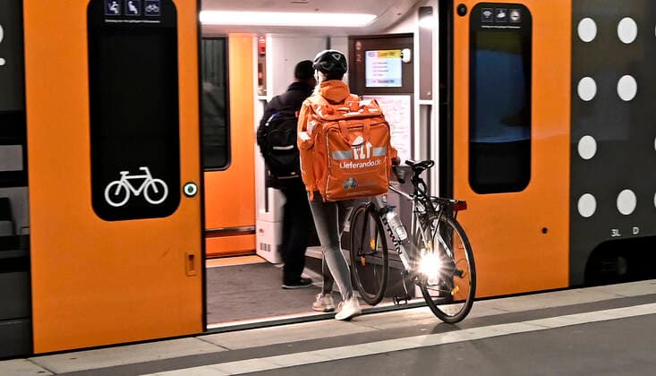 INFEKTIONEN CORONA-ANSTECKUNG MUND-UND NASENSCHUTZ CORONA -REGELN LOCKDOWN 3 CORONA- IMPFZENTRUM SCHUTZIMPFUNG Nächtliche Ausgangssperre im Zuge der anhaltenden Pandemie.Fahrradkurier von Lieferando steigt in einen Zug im Essener Hauptbahnhof ein ( HBF ),Essen,Stadt im Ruhrgebiet im Bundesland Nordrhein-Westfalen ( NRW ),fotografiert am 25.04.2021. Â