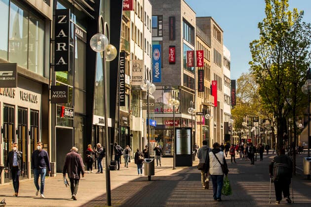 Nur wenige Menschen sind während der Coronapandemie im April 2021 in der Kölner Innenstadt - wie hier auf der Schildergasse - zum Einkaufen unterwegs. Die meisten Geschäfte sind geschlossen. Köln