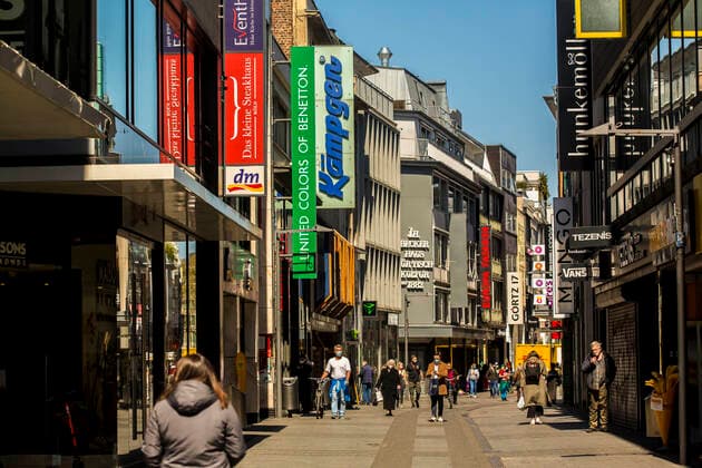 Nur wenige Menschen sind während der Coronapandemie im April 2021 in der Kölner Innenstadt - hier auf der Hohe Straße - zum Einkaufen unterwegs. Die meisten Geschäfte sind geschlossen. Köln
