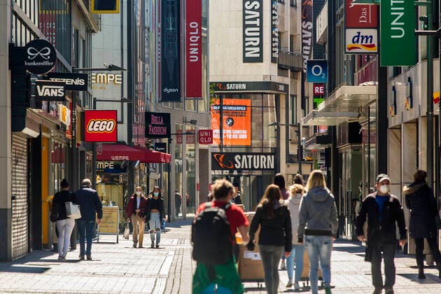 Nur wenige Menschen sind während der Coronapandemie im April 2021 in der Kölner Innenstadt - hier auf der Hohe Straße - zum Einkaufen unterwegs. Die meisten Geschäfte sind geschlossen. Köln