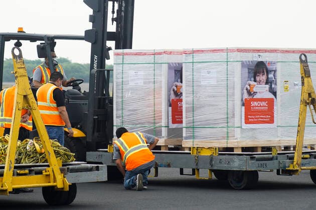 April 26, 2021, San Luis Talpa, El Salvador: Logistic workers unload a container with the CORONAVAC vaccine doses during the arrival..Salvadoran President Nayib Bukele announced that the country has acquired half a million doses of the Chinese manufactured CORONAVAC COVID-19 vaccine. San Luis Talpa El Salvador - ZUMAs197 20210426_zaa_s197_104 Copyright: xCamiloxFreedmanx