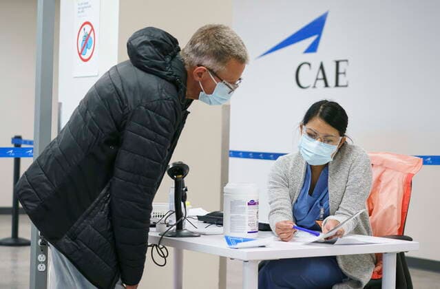 April 26, 2021, Montreal, PQ, Canada: An employee is registered at a COVID-19 vaccination clinic at CAE headquarters in Montreal, on Monday, April 26, 2021. A provincial program to provide vaccinations at large businesses began today at the Montreal headquarters of the flight simulation technology manufacturer. Montreal Canada  - ZUMAc35_ 20210426_zaf_c35_054 Copyright: xPaulxChiassonx