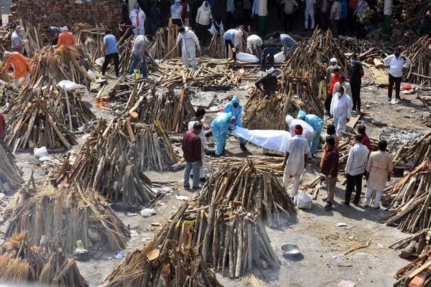 NEW DELHI, INDIA - APRIL 26: Funeral pyres of people who died of Covid-19 being prepared simultaneously at Gazipur crematorium on April 26, 2021 in New Delhi, India. India has registered 2,762 new deaths and 319,315 new infections recording more than 300,000 daily Covid-19 cases for the fifth day in a row, reaching a new record peak. (Photo by Raj K Raj Hindustan Times) Cremation Of Covid-19 Victims
